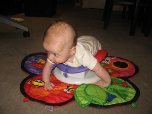 Aujourd'hui, maman m'a achete un tapis de jeux qui me permet de me mettre sur le ventre et de travailler mes muscles du cou!En plus ca tourne et je peux jouer en meme temps!